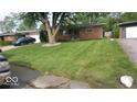Brick ranch home with a tree, lawn, and driveway at 4013 N Audubon Rd, Indianapolis, IN 46226