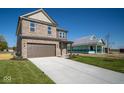 Two-story brick home with brown garage door, next to a house under construction at 1402 Foxtail Ln, Greenwood, IN 46143