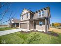 Two-story brick home with brown garage door and landscaped lawn at 1402 Foxtail Ln, Greenwood, IN 46143