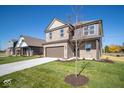 Two-story brick home with brown garage door and landscaped lawn at 1402 Foxtail Ln, Greenwood, IN 46143