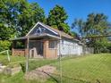 Gray sided home with a covered porch and chain link fence at 2221 Langley Ave, Indianapolis, IN 46218