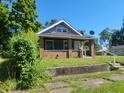 Brick and gray sided home with a covered porch at 2221 Langley Ave, Indianapolis, IN 46218