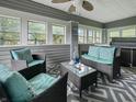 Spacious enclosed porch featuring comfortable seating and a ceiling fan at 5647 W Mooresville Rd, Indianapolis, IN 46221