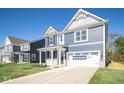 Two-story home with a blue exterior, two-car garage and landscaping at 1678 Orchard Dr, Fortville, IN 46040