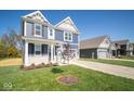 Two-story home with a blue exterior, two-car garage and landscaping at 1678 Orchard Dr, Fortville, IN 46040