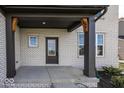 Covered porch with dark brown columns and a dark gray door at 9317 Coopers Ln, McCordsville, IN 46055