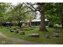 Landscaped yard with large rocks and mature trees at 9100 S Us Highway 35, Muncie, IN 47302