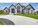 Luxury home with stone exterior and circular driveway at 9760 Windy Hills Dr, Zionsville, IN 46077