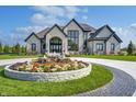 Luxury home showcasing landscaping and circular drive at 9760 Windy Hills Dr, Zionsville, IN 46077