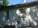 White sided house with damaged window and overgrown vegetation at 2901 S Taft Ave, Indianapolis, IN 46241