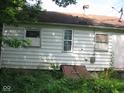 White sided house with damaged window and a basement door at 2901 S Taft Ave, Indianapolis, IN 46241