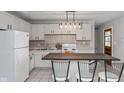 Eat-in kitchen with white cabinets, island, and tile backsplash at 975 Rolling Hill Rd, Greenwood, IN 46142