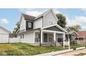 Two-story house with gray siding, front porch, and detached garage at 207 Wisconsin St, Indianapolis, IN 46225