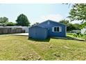 Backyard view showing a blue house with a patio, shed and grassy area at 2813 Grassy Creek Dr, Indianapolis, IN 46229