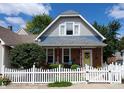 Charming 2-story home with gray siding and white picket fence at 32 E Caven St, Indianapolis, IN 46225