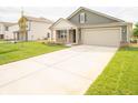 New single-story home with green siding, brick accents, and a two-car garage at 7721 Big Bend Blvd, Camby, IN 46113