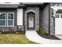 Inviting front entrance with stone detailing and arched entryway at 15827 Scarteen Rd, Fishers, IN 46040