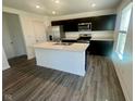 Spacious kitchen with an island, stainless steel appliances, and dark wood cabinets at 6260 Card Blvd, Indianapolis, IN 46221