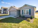 Ranch style home with gray garage door and landscaping at 6205 Card Blvd, Indianapolis, IN 46221