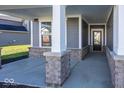 Covered front porch with brick columns and gray siding at 6425 Ambassador Dr, Plainfield, IN 46168