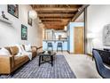 Open living area with exposed beams, leather sofa, and a modern aesthetic at 735 Lexington Ave # Apt 8, Indianapolis, IN 46203
