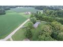 Aerial view showcasing a ranch house nestled among lush greenery and farmland at 4463 W 700 S, Trafalgar, IN 46181