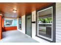 Quaint front porch with a green door, wood ceiling, and brick columns at 4711 Guilford Ave, Indianapolis, IN 46205