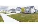 Houses with gray siding, stone accents, and two-car garages in a neighborhood setting at 1815 River Birch Dr, Greenfield, IN 46140