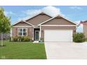 House exterior with a white garage door and landscaped lawn at 1962 Fairmount Dr, Greenfield, IN 46140