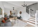 Open living room with gray sofa, glass coffee table, and view of kitchen and stairs at 1046 Dawson St, Indianapolis, IN 46203
