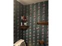 Small bathroom with floral wallpaper and a wooden shelf at 9145 Shenandoah Dr, Indianapolis, IN 46229