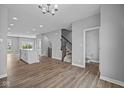 Open living room with hardwood floors and a view of the kitchen and staircase at 7101 Pate Hollow Dr, Brownsburg, IN 46112