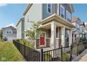 Two-story home with a red door, stone accents, and a black fence at 9264 Hawley Dr, Indianapolis, IN 46216