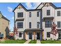 Modern 2-story townhome with gray siding, black windows, and a landscaped front yard at 4190 Douro Trl, Westfield, IN 46062