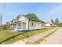 Charming yellow house with gray porch and well-maintained lawn at 728 E Beecher St, Indianapolis, IN 46203