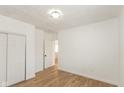 Simple bedroom with wood-look floors and an adjacent bathroom at 728 E Beecher St, Indianapolis, IN 46203