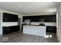 Modern kitchen with dark cabinetry, island, and stainless steel appliances at 140 Hobbs Dr, Whiteland, IN 46184