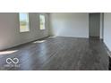 Spacious living room featuring wood-look flooring and large windows at 140 Hobbs Dr, Whiteland, IN 46184