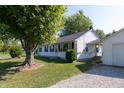 White Ranch home with mature trees and gravel driveway at 941 N 500 W, Columbus, IN 47201