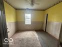 Bedroom with yellow walls, wood paneling, and carpet flooring at 108 N Summit St, Summitville, IN 46070
