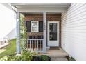 Cozy front porch with brick facade and seating at 4620 Whitham Ln, Indianapolis, IN 46237