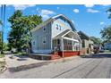 Side view of a charming two-story home with gray siding and a red base at 1938 E 11Th St, Indianapolis, IN 46201