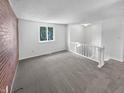 Living room with carpet, brick wall, and loft view at 2647 Sheffield Dr, Indianapolis, IN 46229