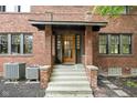 Brick home exterior with a charming covered entryway and steps leading to the front door at 3860 N Delaware St, Indianapolis, IN 46205
