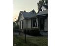 Quaint white house with black accents and a chain link fence at 1804 N Delaware St, Indianapolis, IN 46202