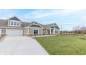View of a house with a driveway, attached garage, and green lawn at 6210 Fairview Dr, McCordsville, IN 46055
