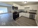 Modern kitchen with white cabinets, gray countertops, and stainless steel appliances at 4050 Byram Ave, Indianapolis, IN 46208