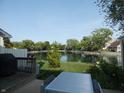 Deck overlooks a pond with landscaping and homes in the background at 7419 Sylvan Ridge Rd, Indianapolis, IN 46240