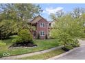 Brick two-story house with a manicured lawn and landscaping at 8418 Mesic Ct, Indianapolis, IN 46278