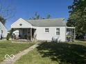 White house with a covered porch and a manicured lawn at 616 W 38Th St, Anderson, IN 46013